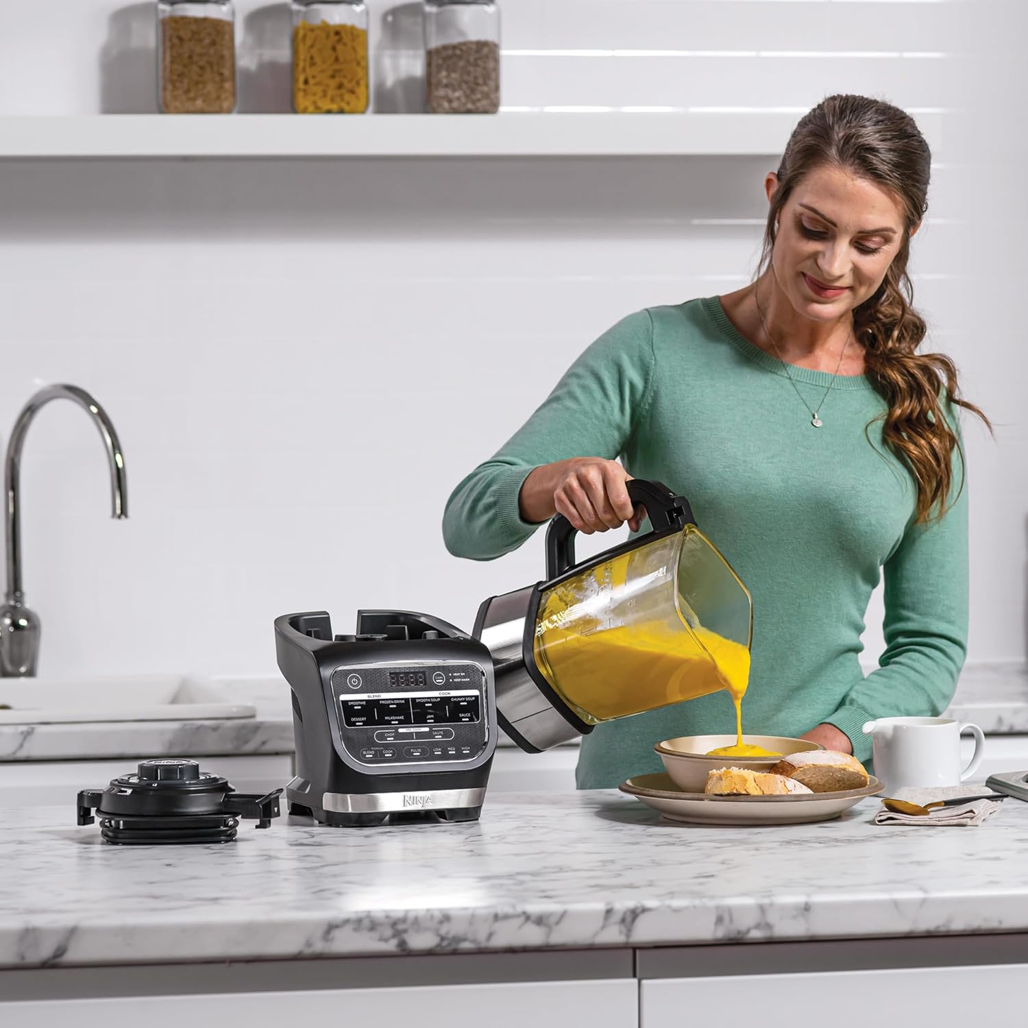 A person pouring finished soup from the Ninja Foodi HB150EU into a bowl.