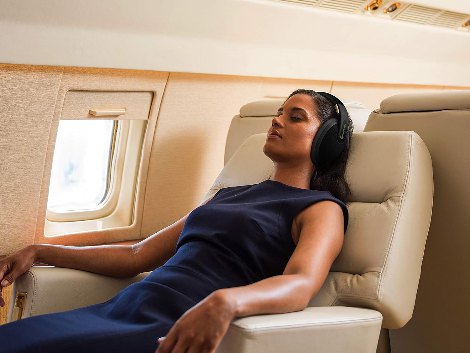 Person sleeping on an airplane with Kokoon headphones