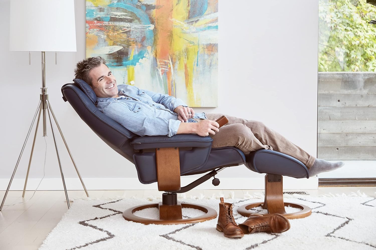 Person comfortably reclining in a Fjords Admiral R chair in blue leather