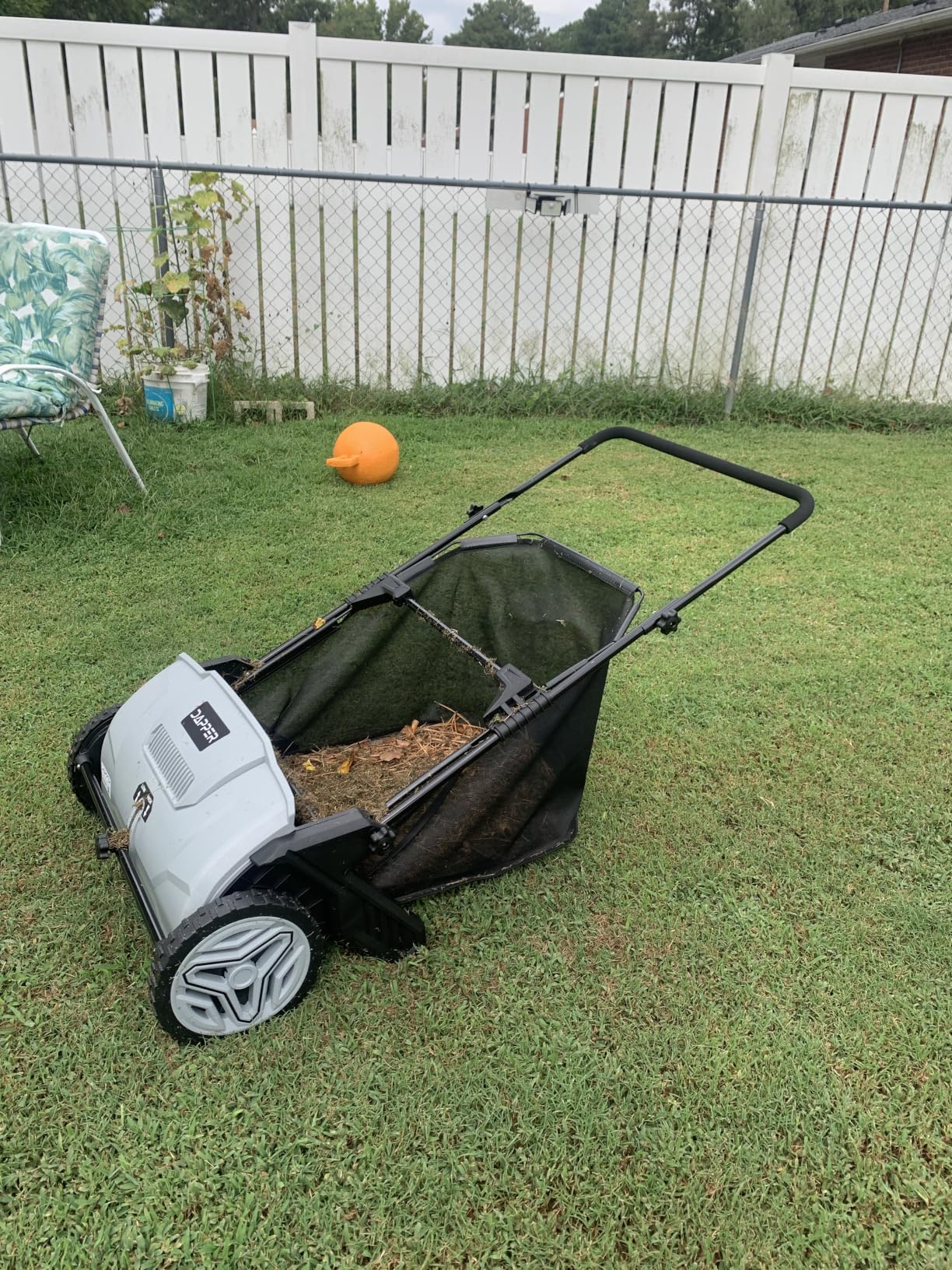Lawn sweeper brush and hopper close-up on a mowed lawn