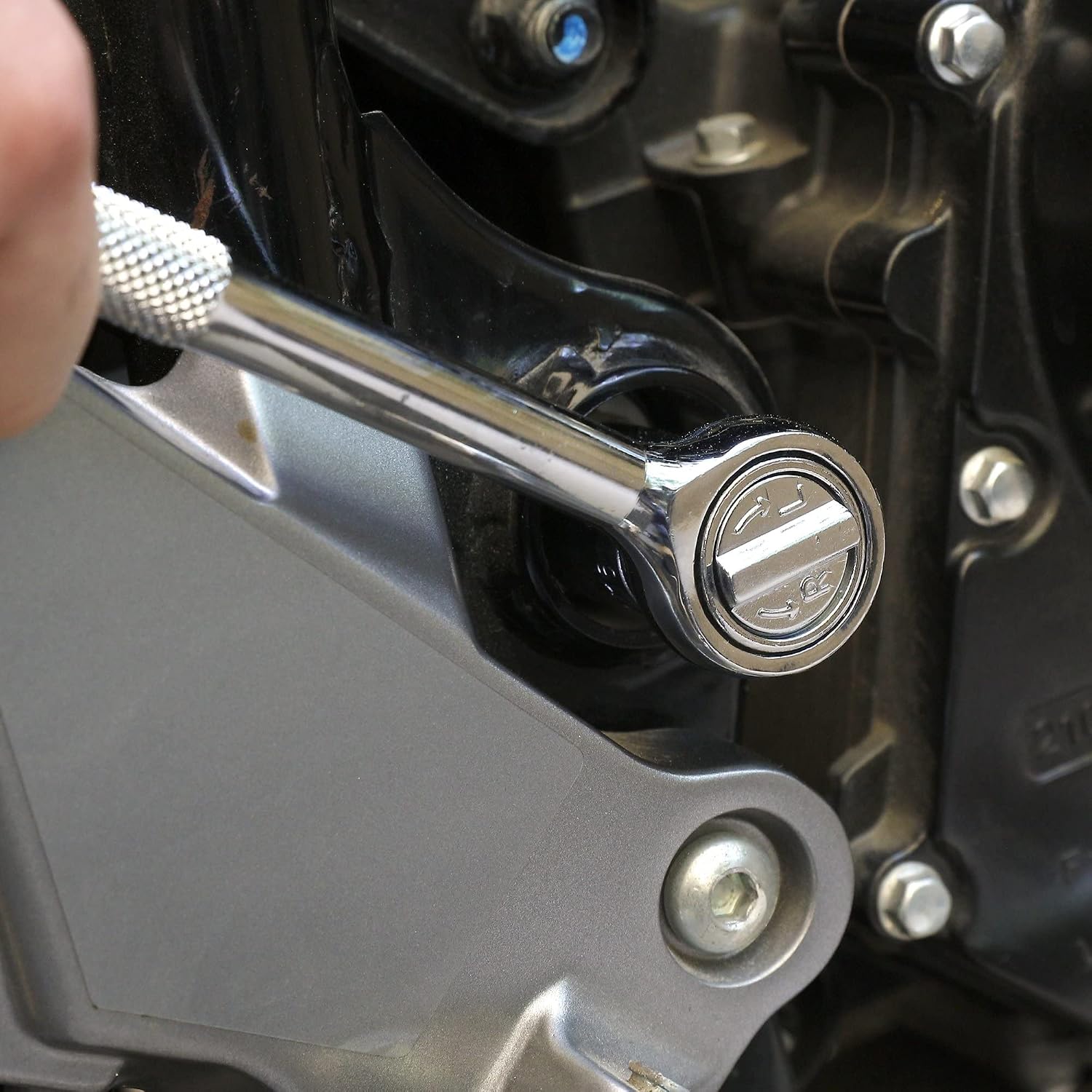 Hand using a ratchet on an engine part