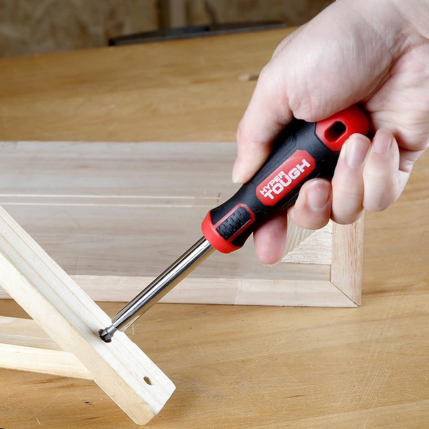 Hand using a magnetic screwdriver handle with a bit