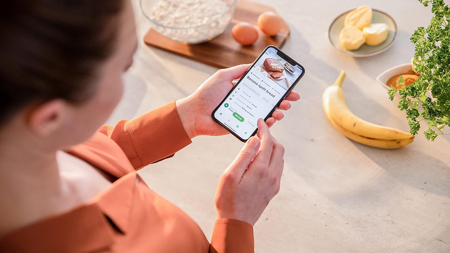 Person using the HomeID app on a smartphone to find recipes