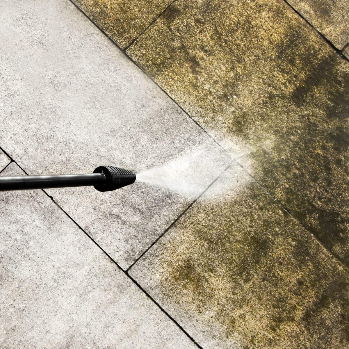 Pressure washer cleaning a dirty patio