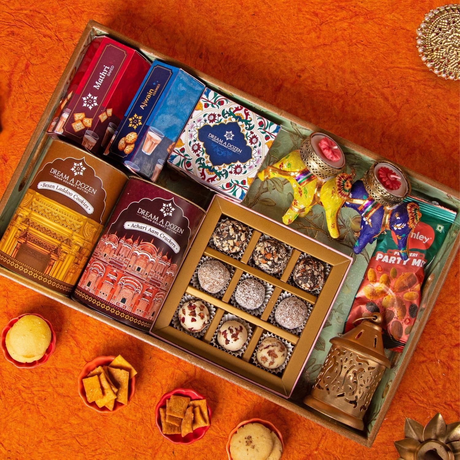 Dream a Dozen Regal Peacock Gift Hamper | Royal Diwali Gift Tray 10x16 Inch with Besan Laddoo Cookies, Achari Aam Crackers, Ajwain Cookies, Mathri Crackers, Peri Peri Mixed Nuts, Pack of 9 Maharani Chocolate Truffles, Lasercut Metal Lantern, Elephant Tealight Holders, Festive Candles & Greeting Card | Luxury Corporate & Festive Gift Box-image-23