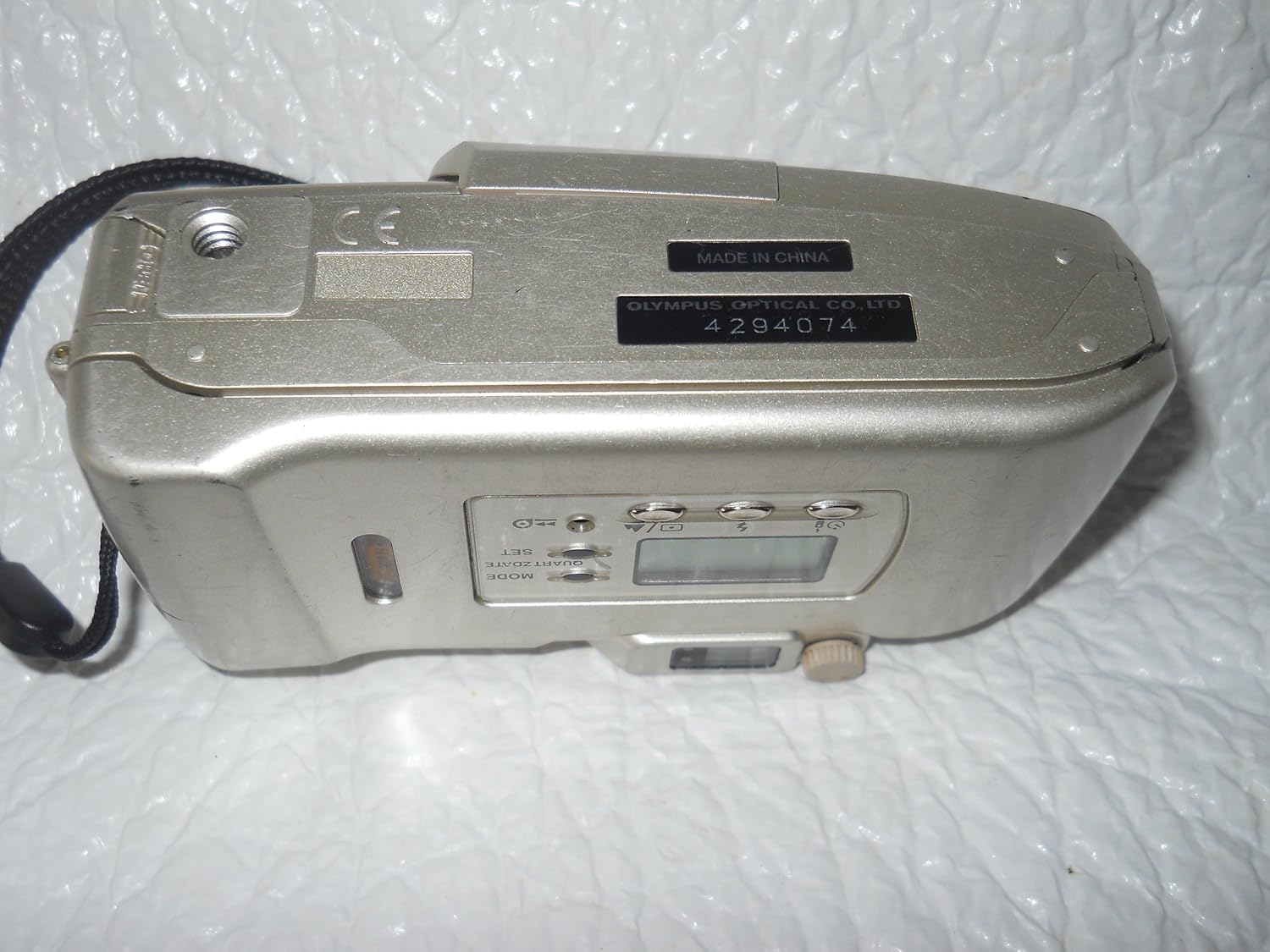 Отдолу view of OM SYSTEM OLYMPUS Stylus 120 camera showing battery compartment