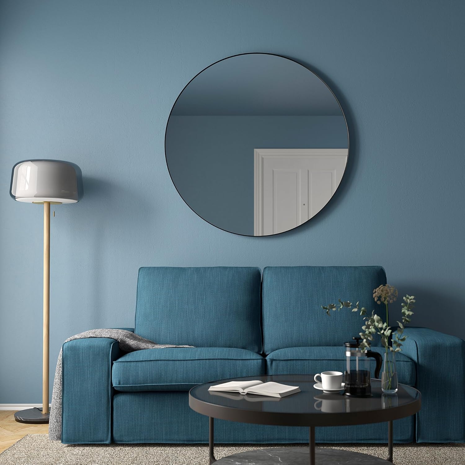 LINDBYN mirror in a living room setting above a blue sofa.