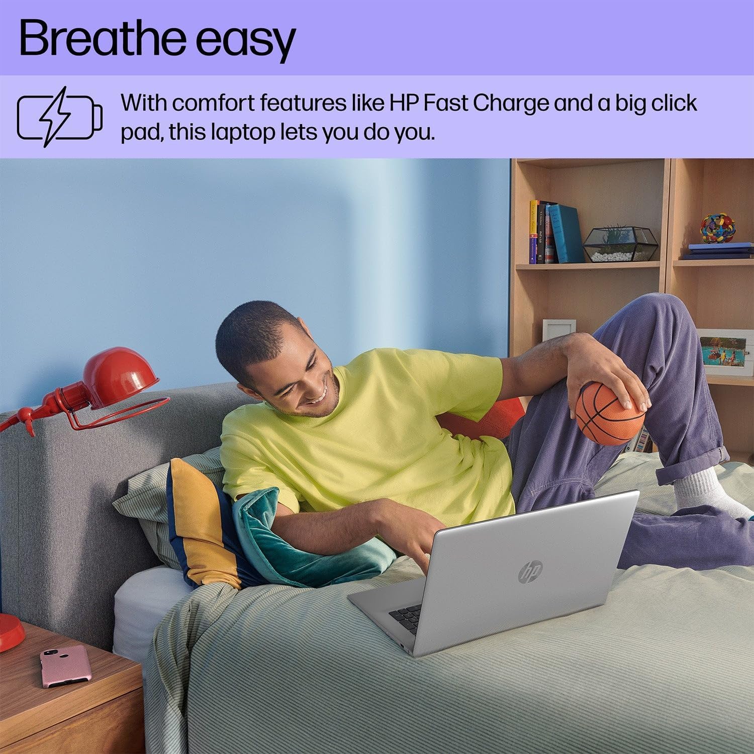 User comfortably using HP 17 Laptop on a bed