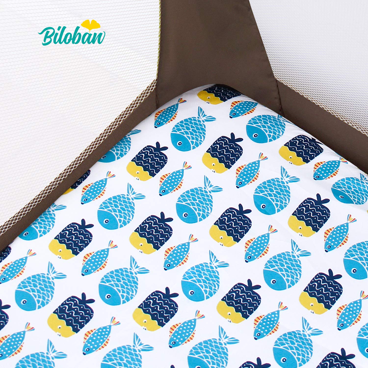 Biloban fitted sheet with fish pattern installed on a playard mattress.