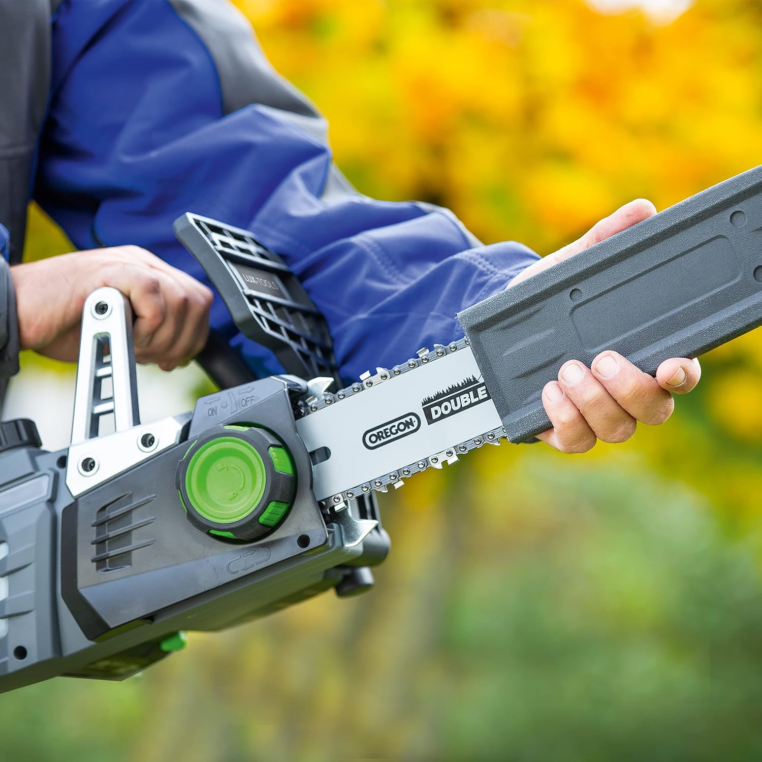 Person attaching guide bar cover to LUX-TOOLS A-KS-20/25 Chainsaw