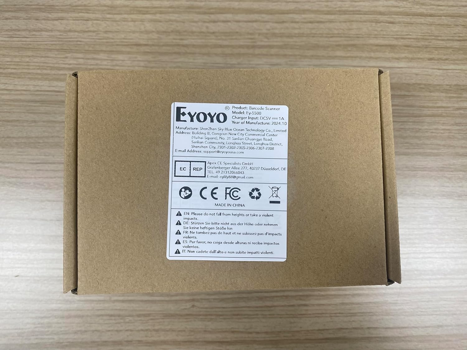 Top view of the Eyoyo EY-5500 barcode scanner's retail packaging, showing product information and certifications.