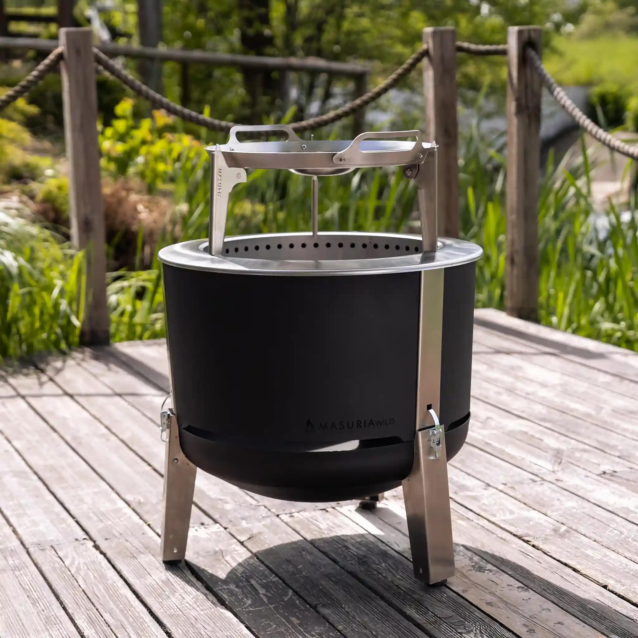 Masuria Brasero Exterieur sans fumée 60cm⌀ Alpha 600 - Croix de Pot, Bar, Plancha, Couvercle, Brochettes Inclus - Réduction de fumée brevetée jusqu'à 95% - Fabriqué dans l'UE - Pieds réglables