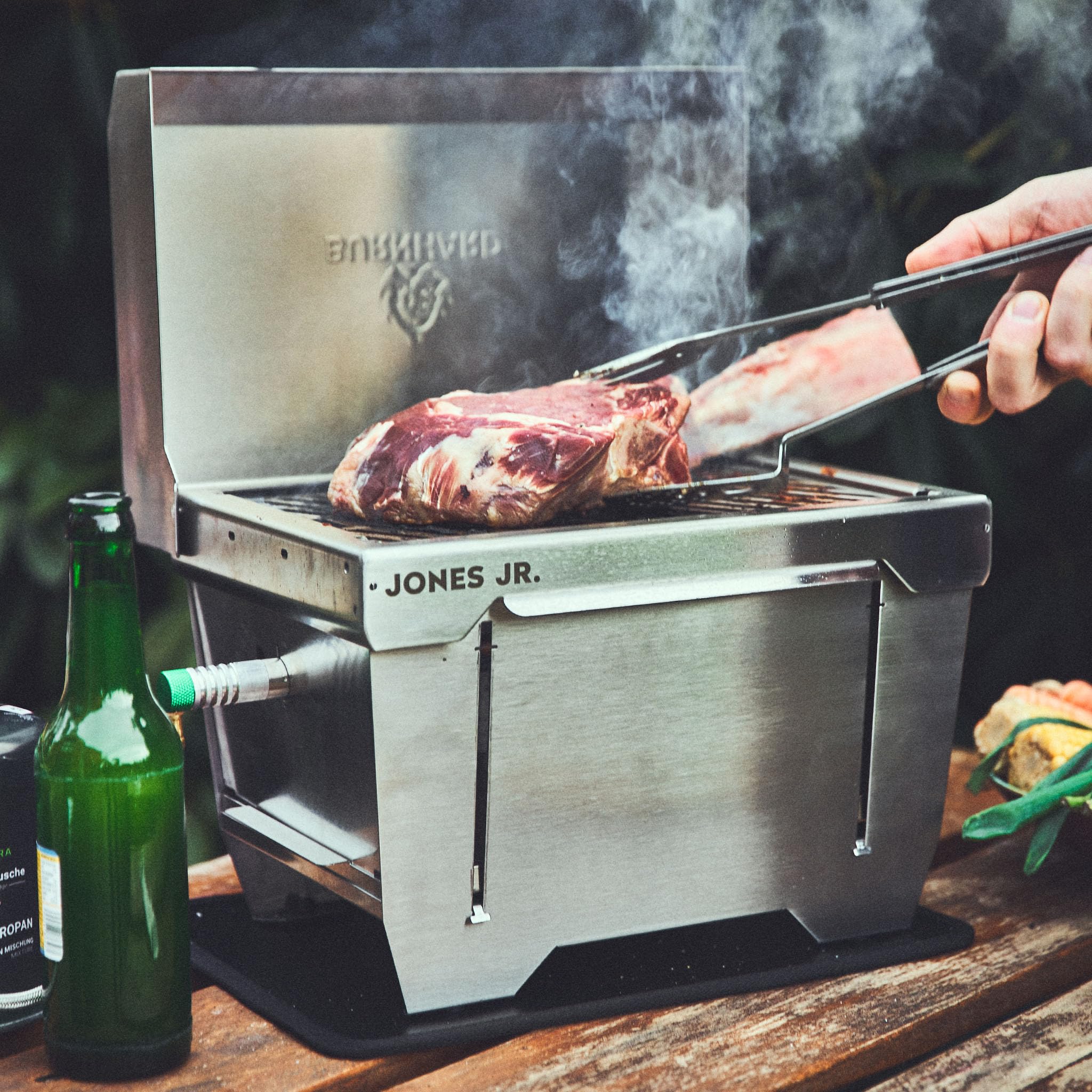 Griglia da campeggio 1-bruciatore BURNHARD® 3,2 kW, 500°C acciaio inox, sistema FitnFire™, ultracompatto, borsa da trasporto, tappetino per griglia – JONES Jr.