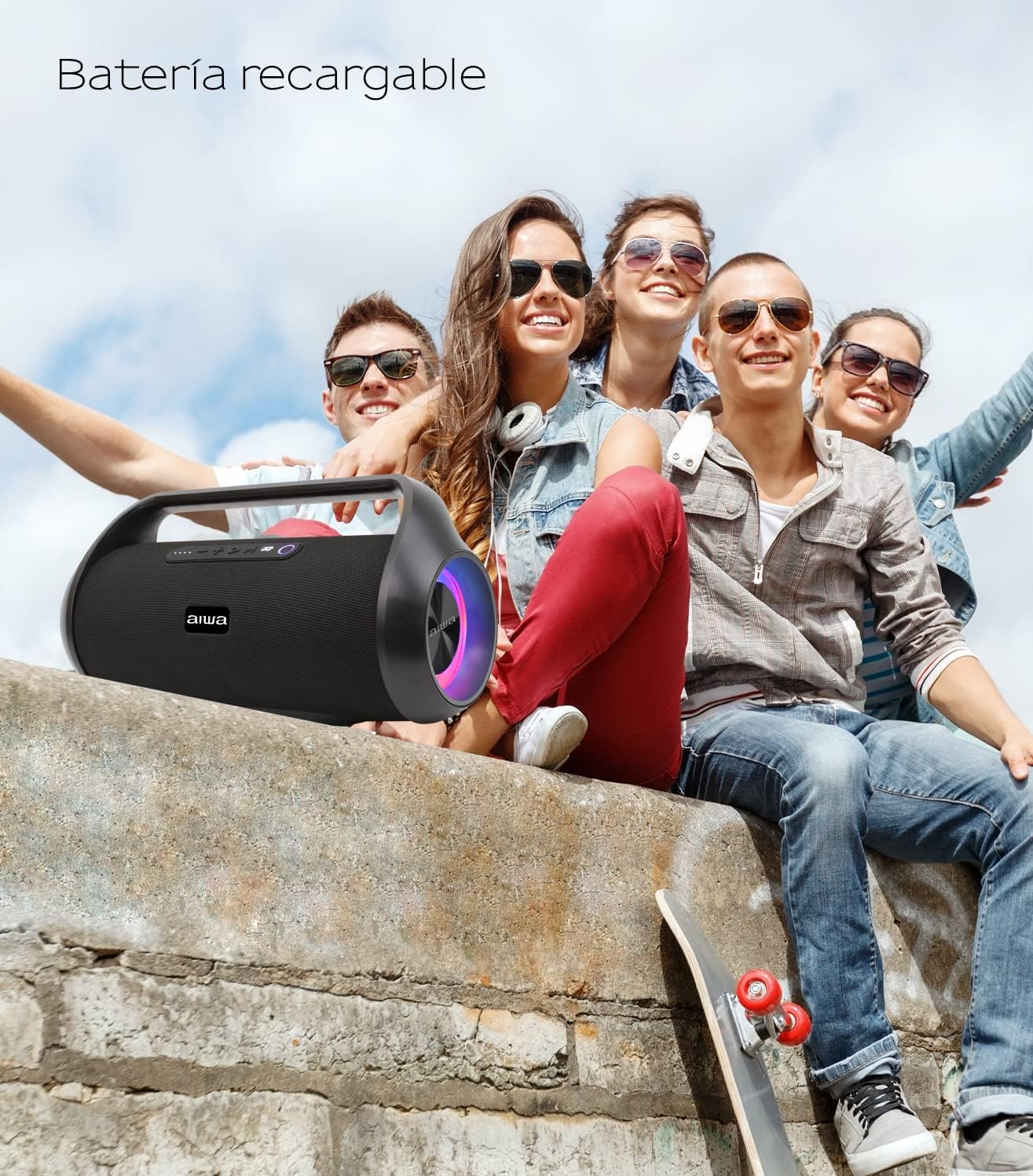 Group of young people sitting outdoors with the Aiwa AWS800BT speaker, illustrating its portability and rechargeable battery feature