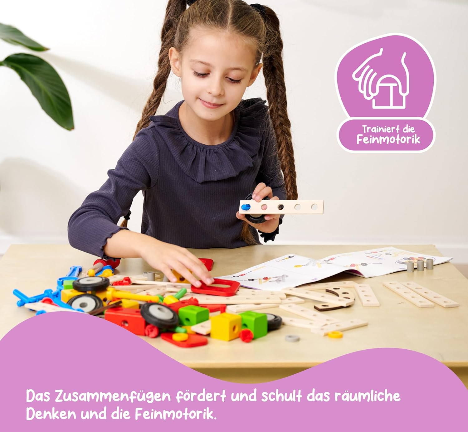 A child with pigtails is focused on assembling a wooden toy, using a screwdriver to connect pieces on a light wooden table.