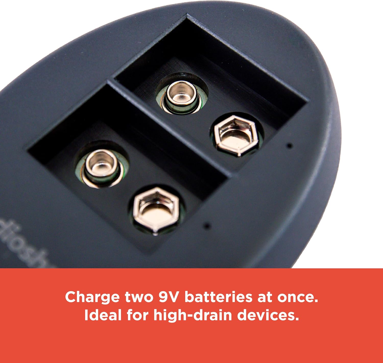 The RadioShack 9V USB Dual Battery Charger connected to a USB power source on a wooden desk, emphasizing its portability.