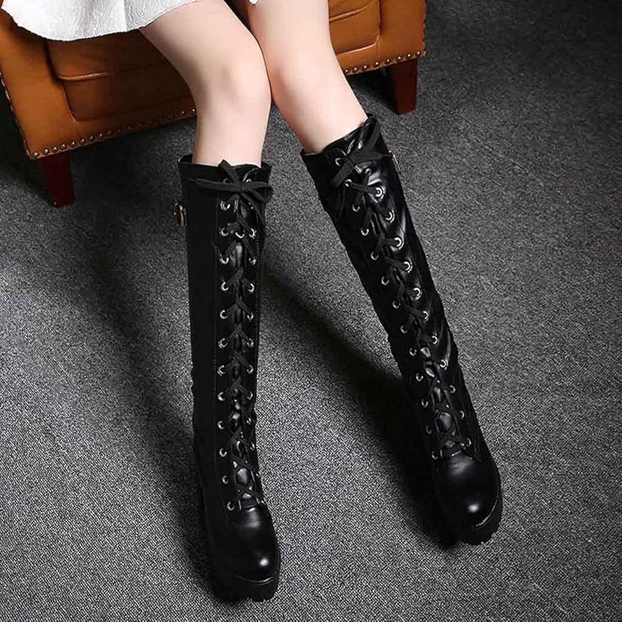 Platform knee high combat boots with chunky heel and lace-up design in black leather showing gothic punk styling
