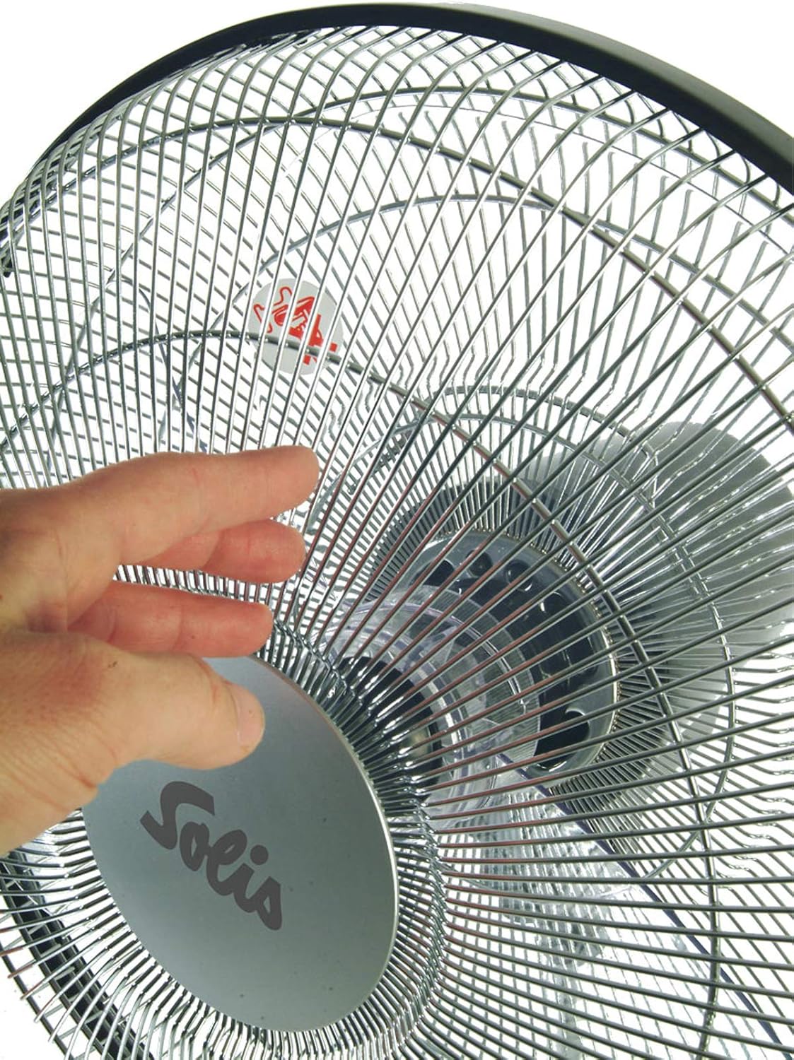 Mână lângă grila ventilatorului, demonstrând caracteristica de siguranță