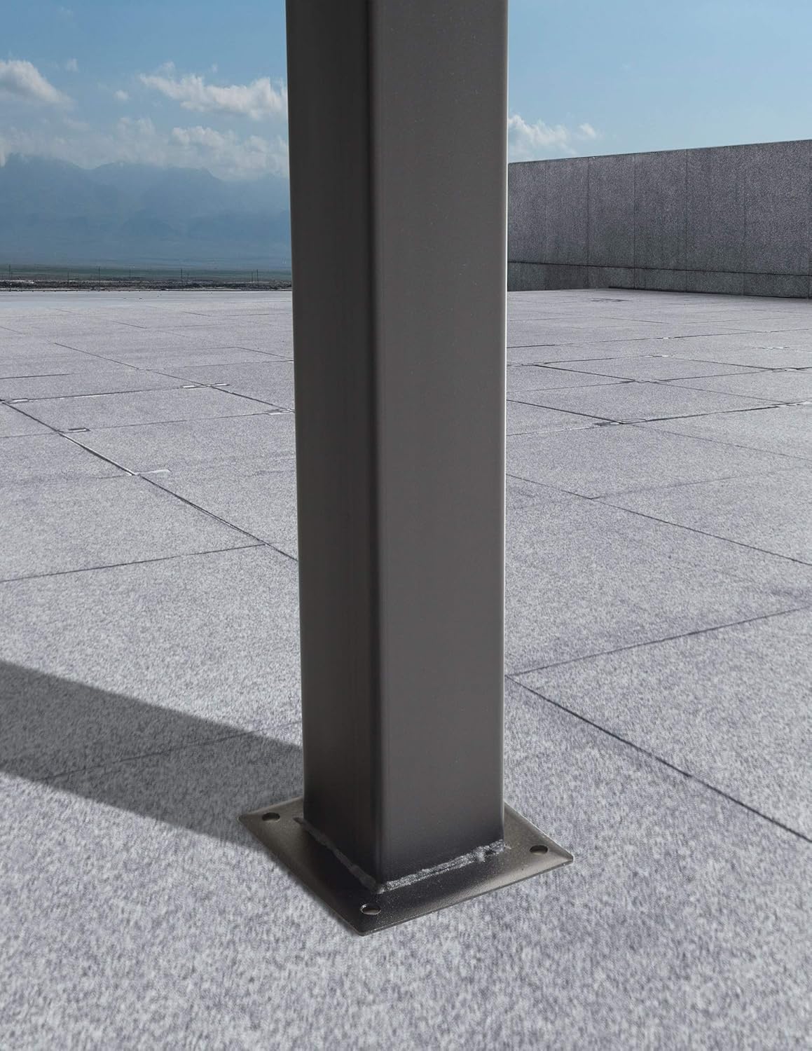 Close-up of a canopy leg base plate with pre-drilled holes for anchoring.