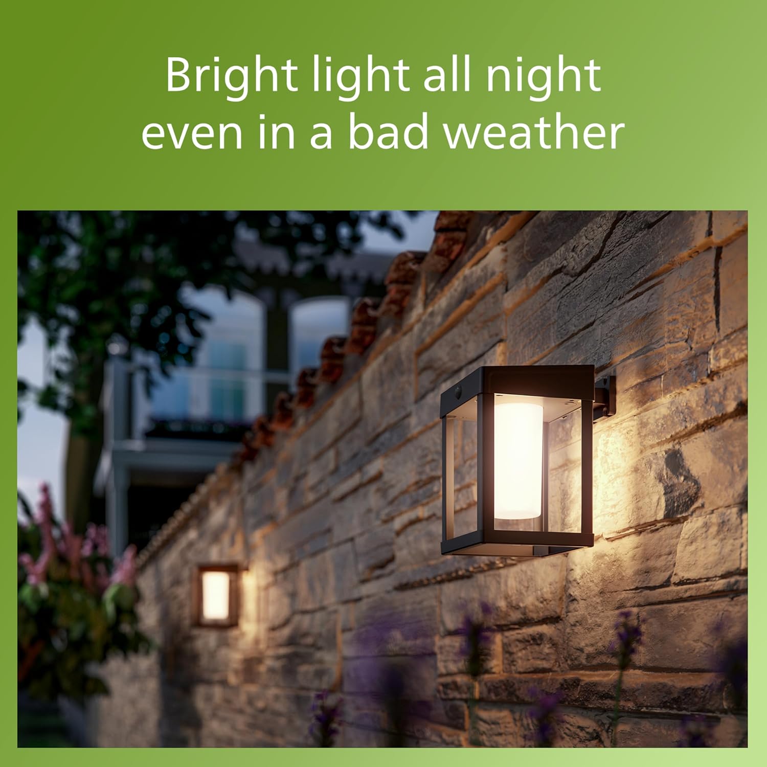 Philips solar wall lantern illuminated at night on a brick wall.