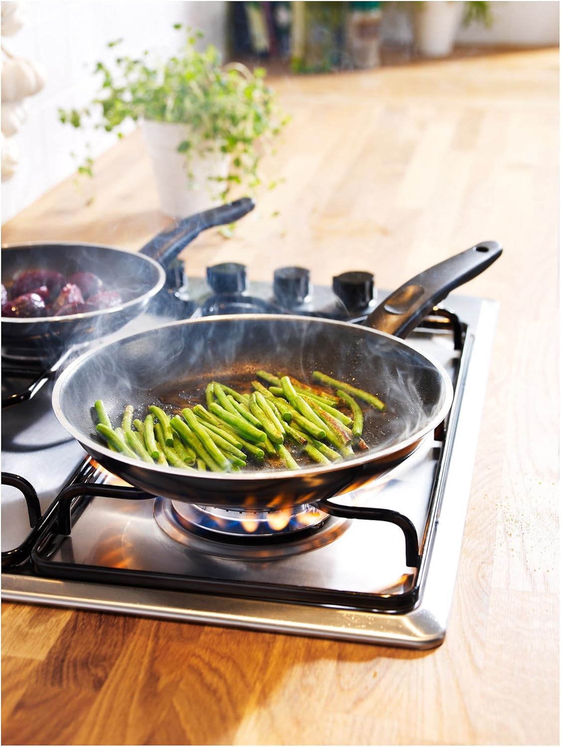 Pánev IKEA Kavalkad na plynovém sporáku, na které se vaří zelené fazolky.