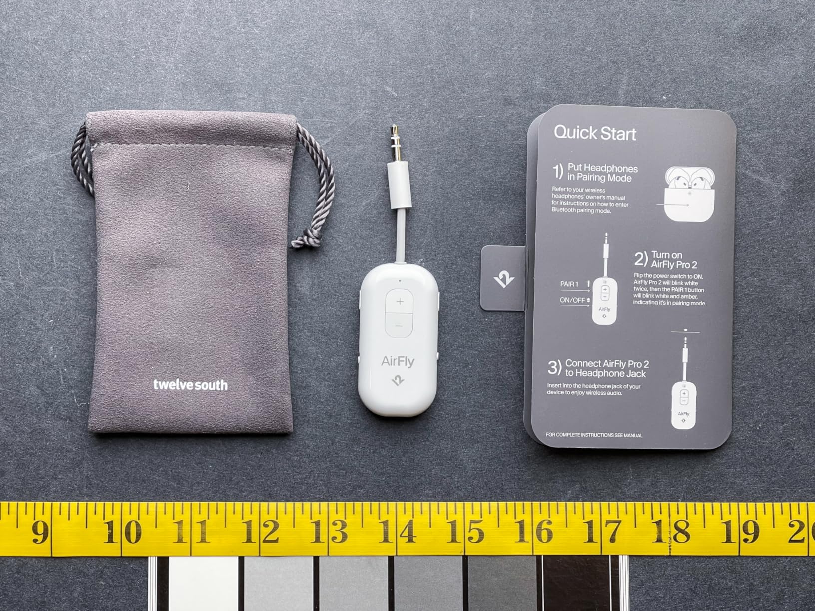 AirFly Pro 2 next to a bag and guide paper showing its width