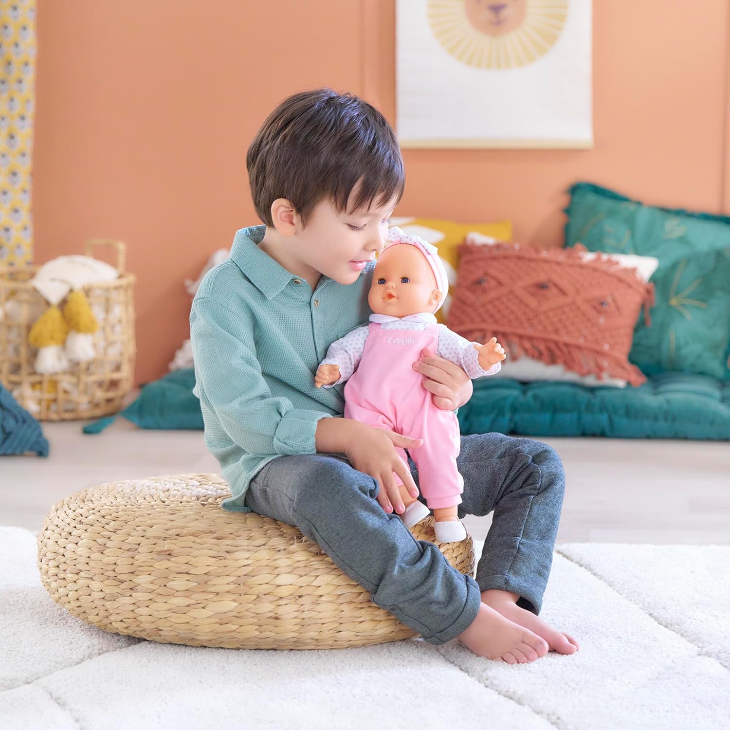 A toddler having a play time with the Corolle Lise Baby Doll