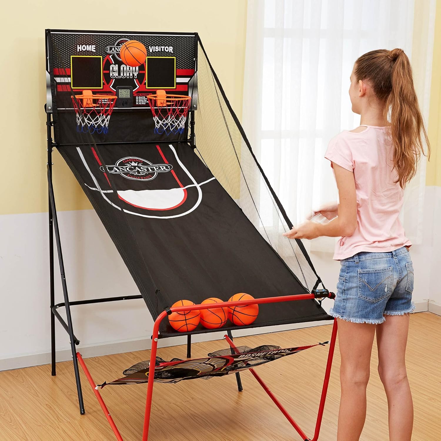 A young boy playing the football and baseball game, throwing a ball towards the target panel.