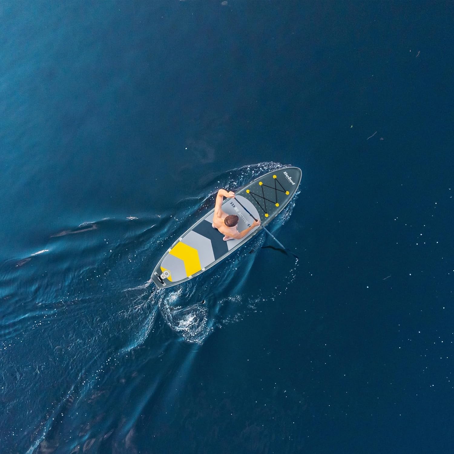 Person paddling the Rebel Brett SUP on calm water from an aerial view.