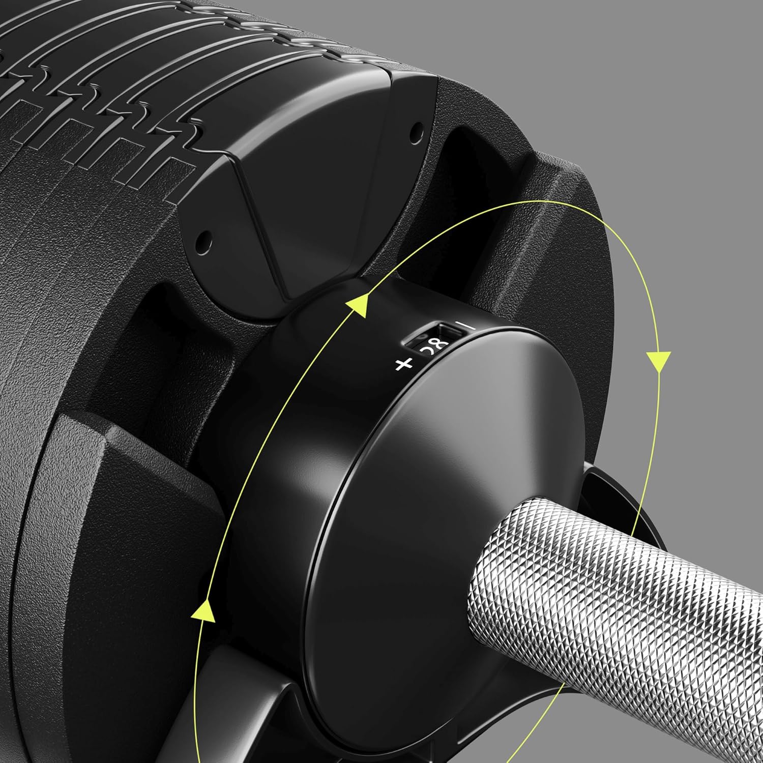 Close-up of the weight selection dial on the dumbbell, showing the plus and minus indicators for adjustment.