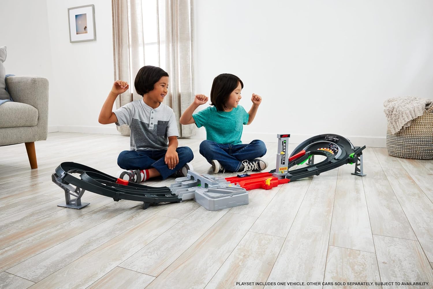 Two children playing with the Hot Wheels Formula 1 Grand Prix Circuit Track Set