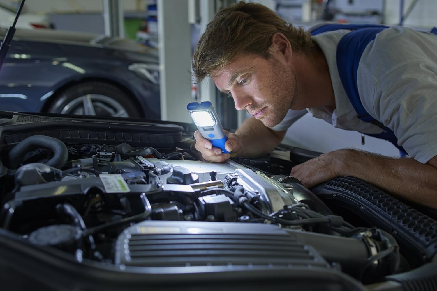 Mechanic inspecting an engine bay with the Philips RCH21 LED Work Light