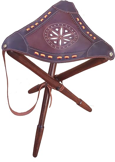 La silla trípode de caza de Tiendas LGP cuenta con un asiento de cuero con detalles de la Bandera de España y patas torneadas en madera de haya. Resistente y estable, incluye una correa de piel para transportarla cómodamente. Ideal para actividades al aire libre como caza, pesca, camping y montañismo.