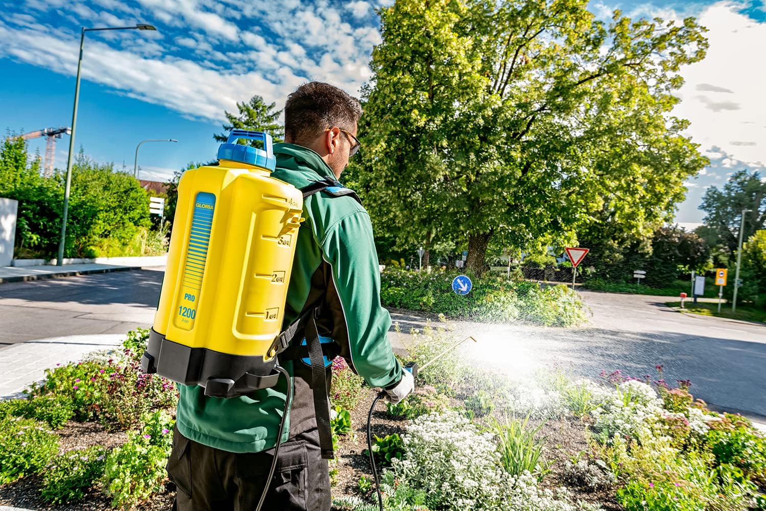 Man spraying weeds or ground cover outdoors with Gloria Pro 1200 li-on back sprayer