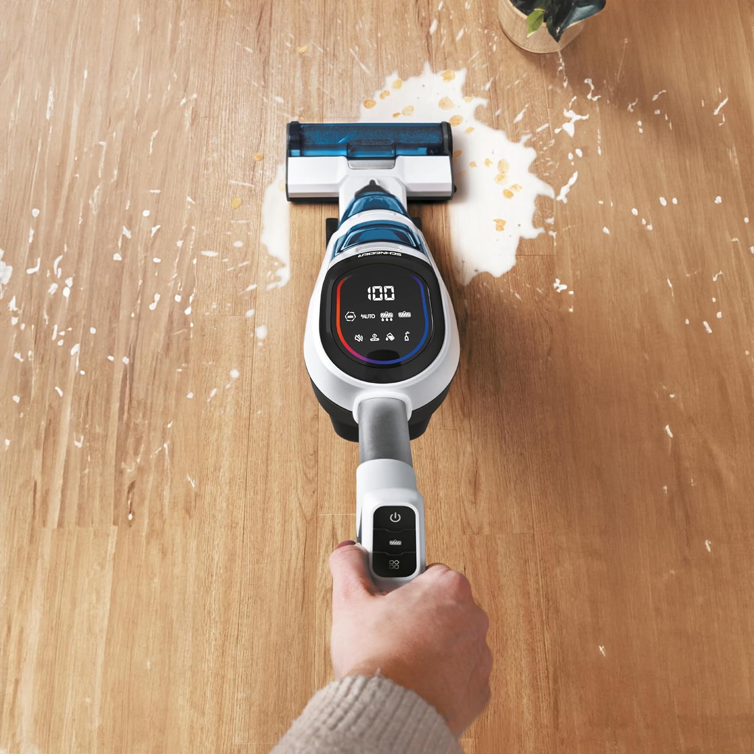 Top-down view of vacuum cleaning a liquid spill with debris