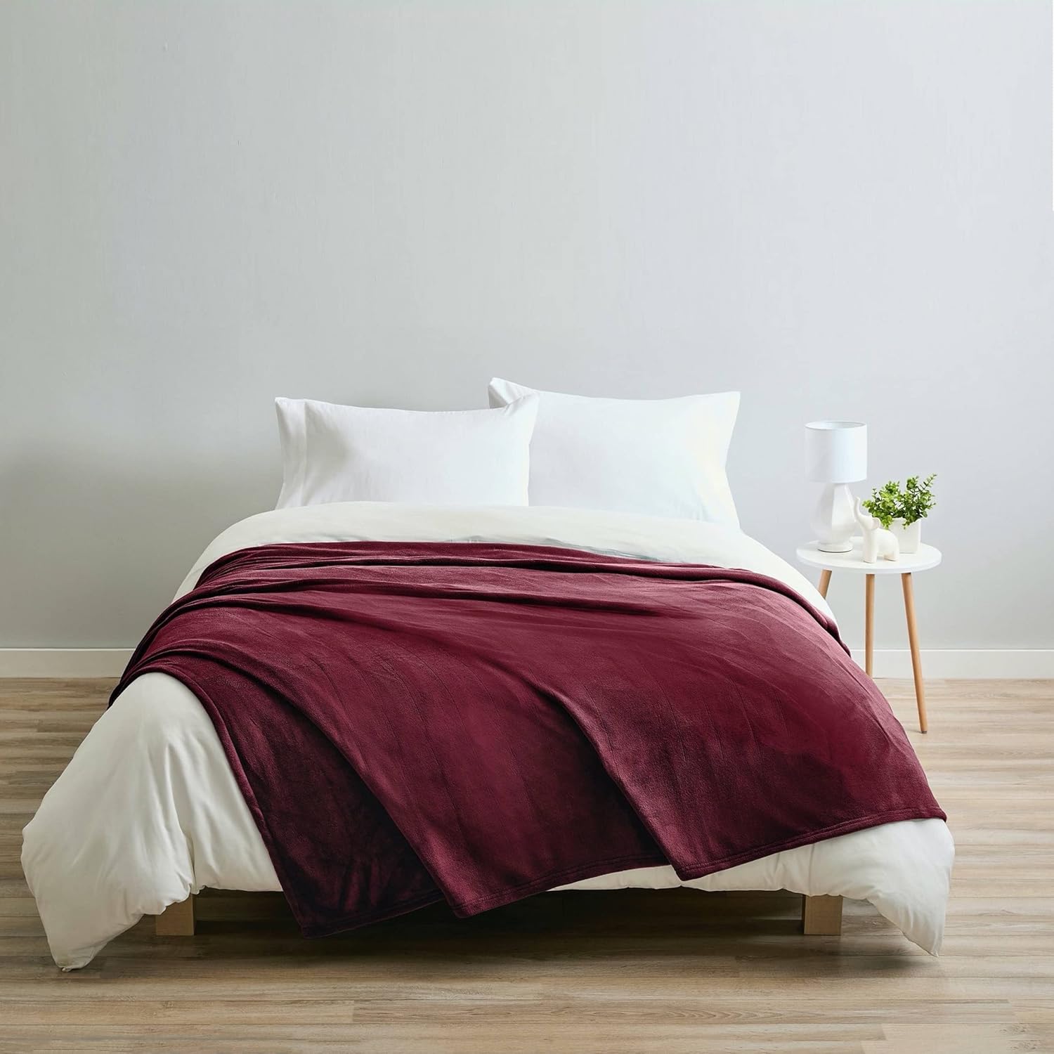 Sunbeam Queen Electric Heated MicroPlush Blanket in Garnet on a bed