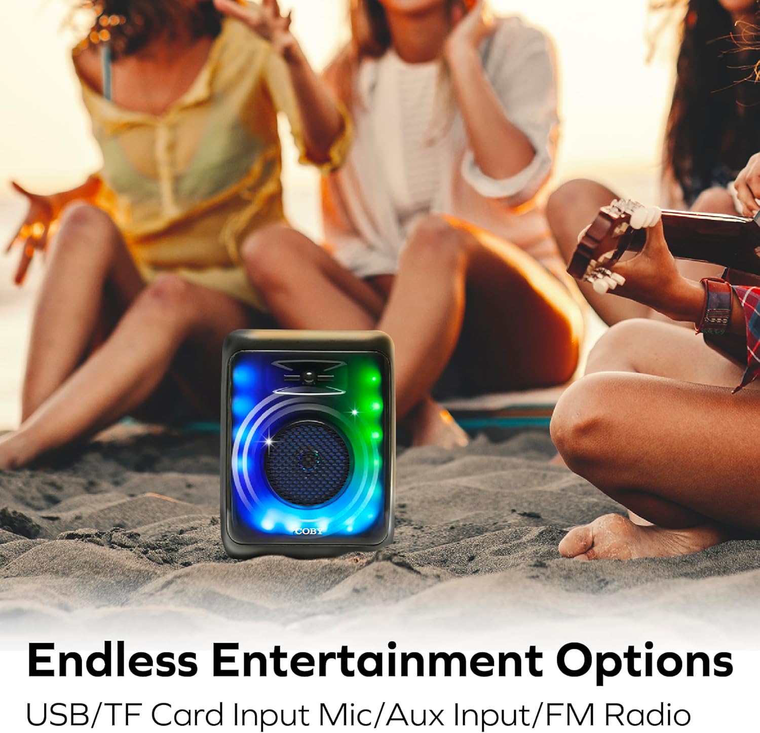 COBY speaker on a beach with people in the background
