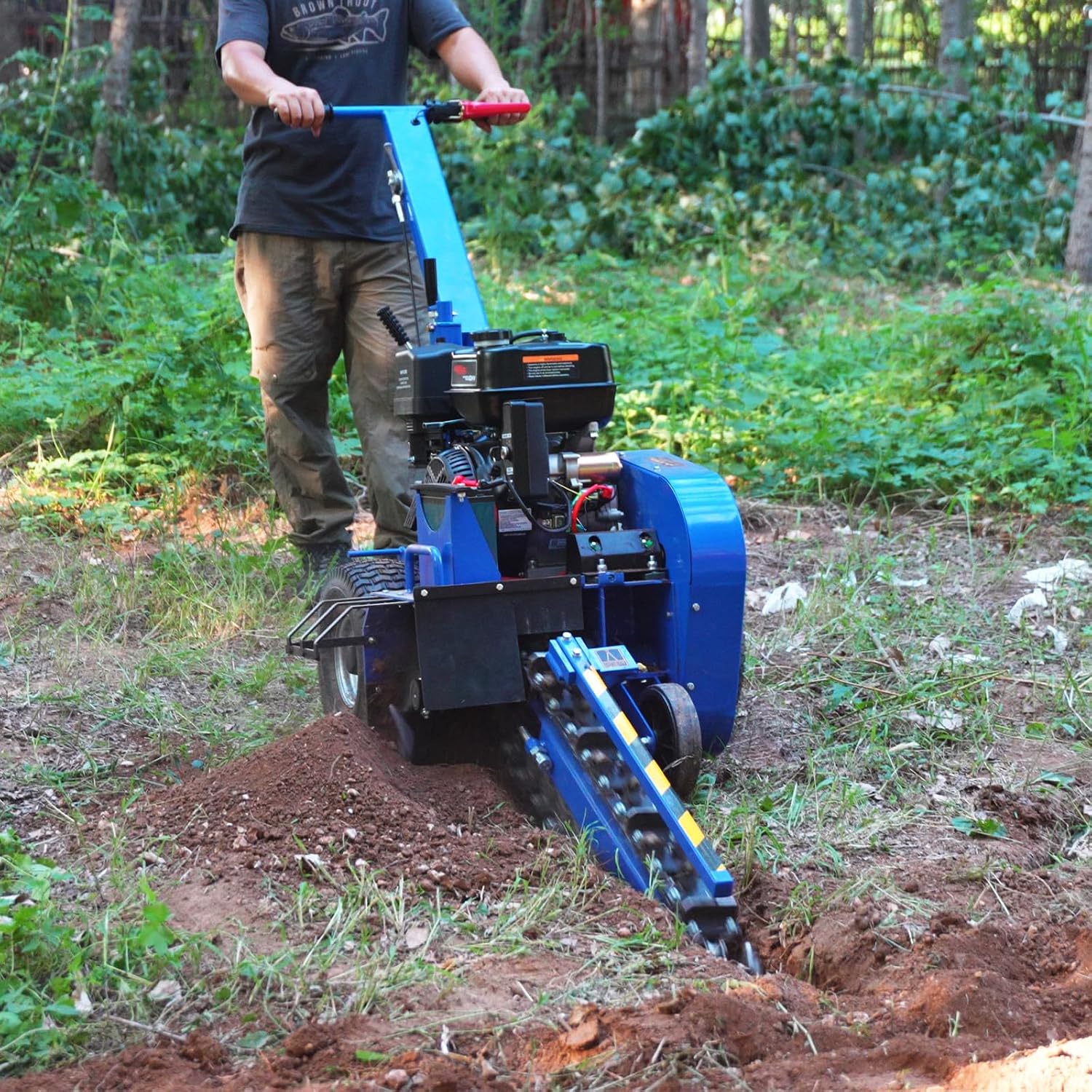 User operating BILT HARD Trencher in a wooded area
