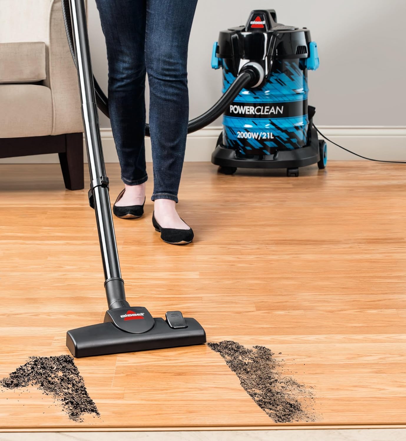 Person vacuuming a hard wooden floor with the Bissell PowerClean 2027E