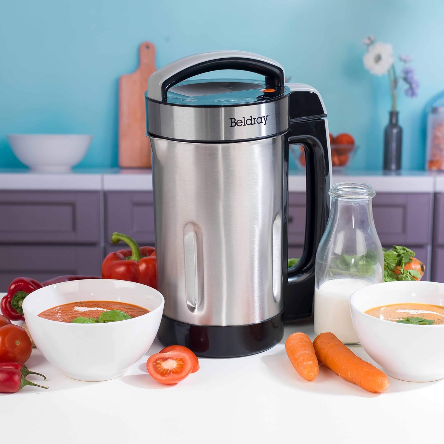 Beldray Soup Maker on a kitchen counter with prepared ingredients and bowls of soup