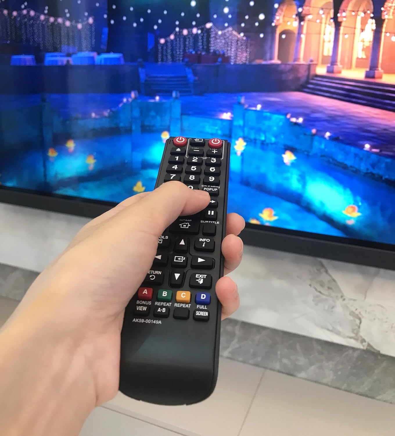 Hand holding the remote control, demonstrating typical usage