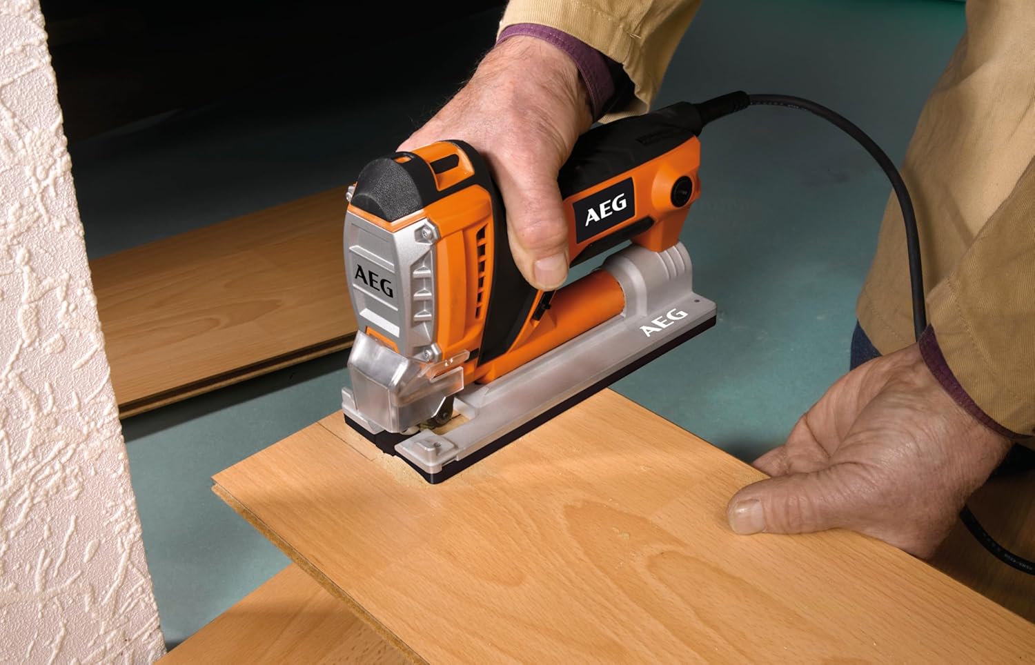 User operating AEG PST 500 X Jigsaw to cut wood