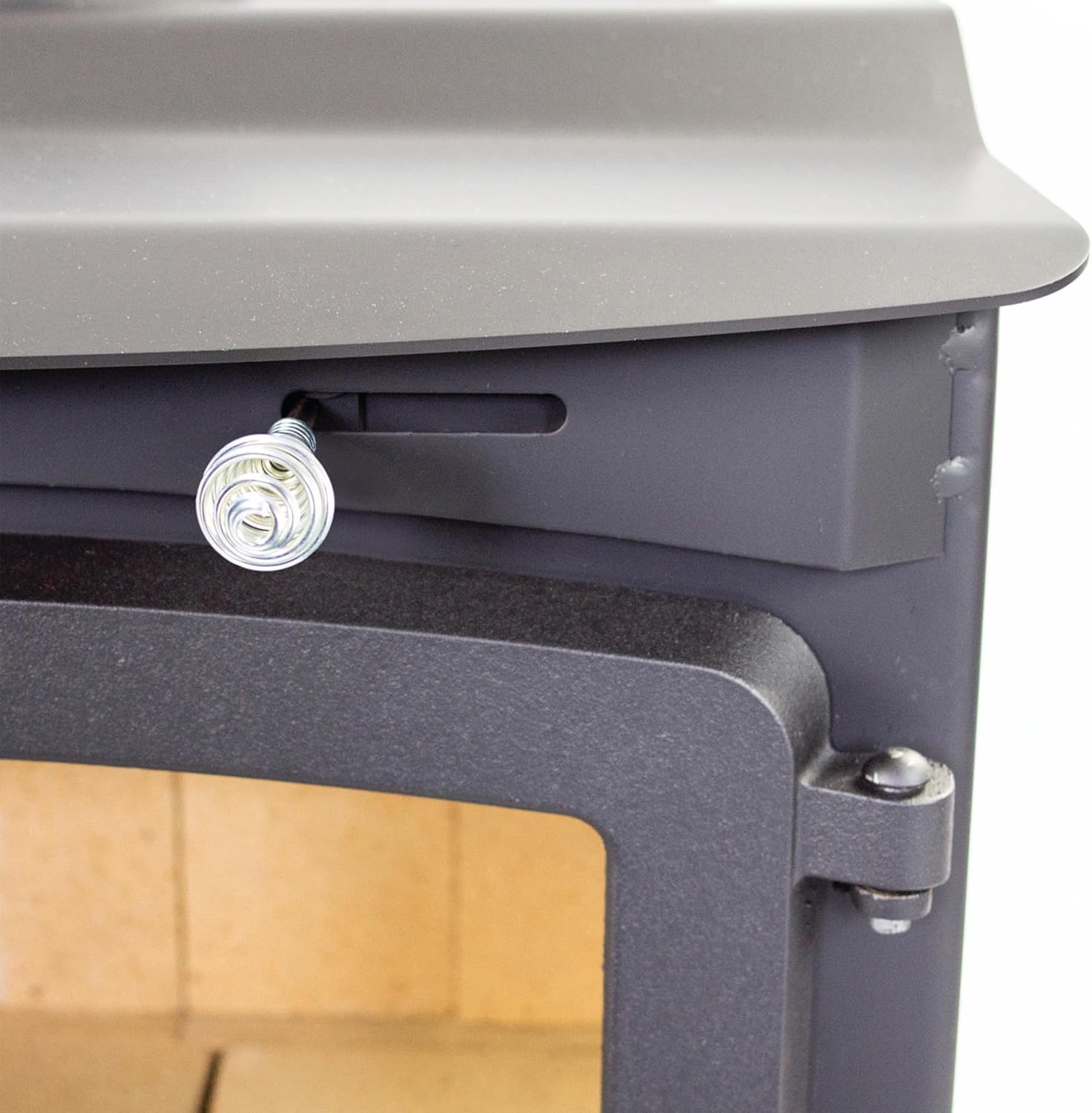 Close-up of the air intake control knob on the front of the wood stove.