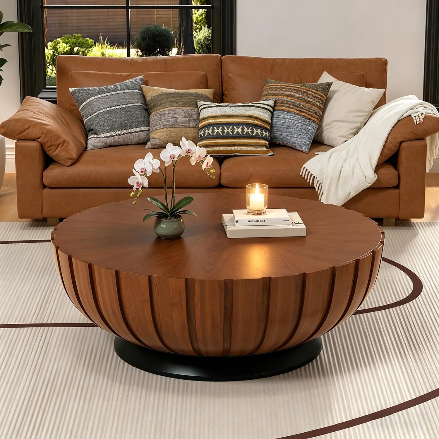 Small round wood coffee table styled with candle and books