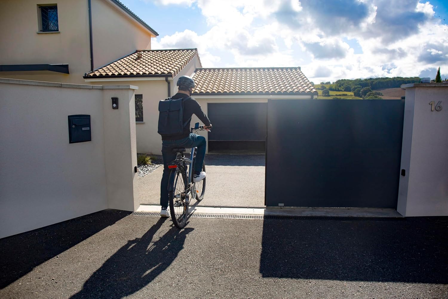 Велосипедчен адам жарым-жартылай ачык дарбазадан кирип баратат