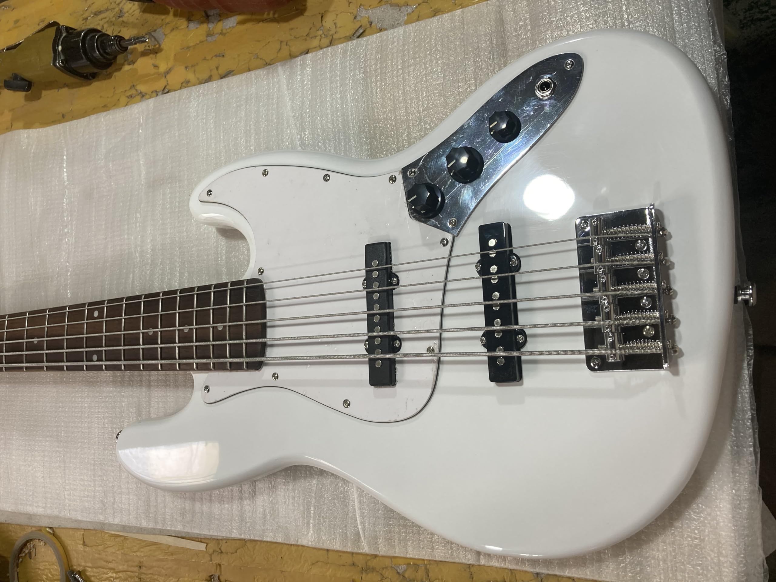 Niestandardowa biała 5-strunowa gitara basowa elektryczna korpus z lipy chromowany sprzęt błyszczącym wykończeniem