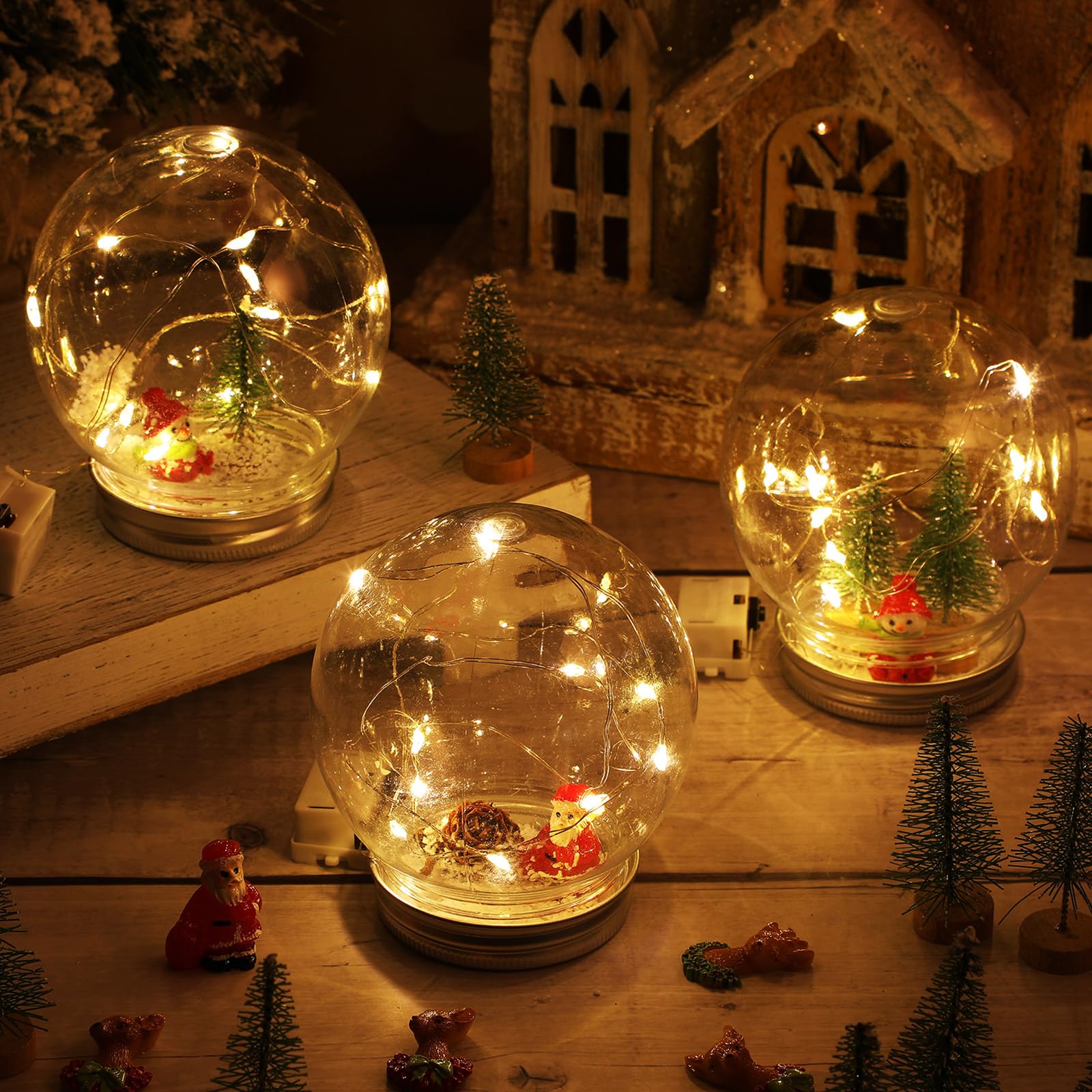 Liliful Lot de 24 boules à neige LED en plastique transparent avec mini sapin de Noël artificiel pomme de pin Père Noël, bonshommes de neige, renne, flocons de neige artificiels pour Noël, vacances,