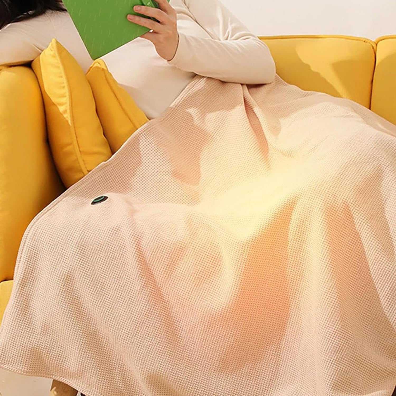 Person covered by the FQFGGYD Portable Heated Blanket on a yellow couch, with a visible warm glow indicating heat.