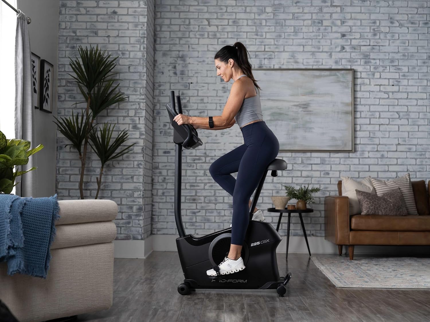 Woman moving the ProForm 225 CSX Exercise Bike by tilting it and rolling it.