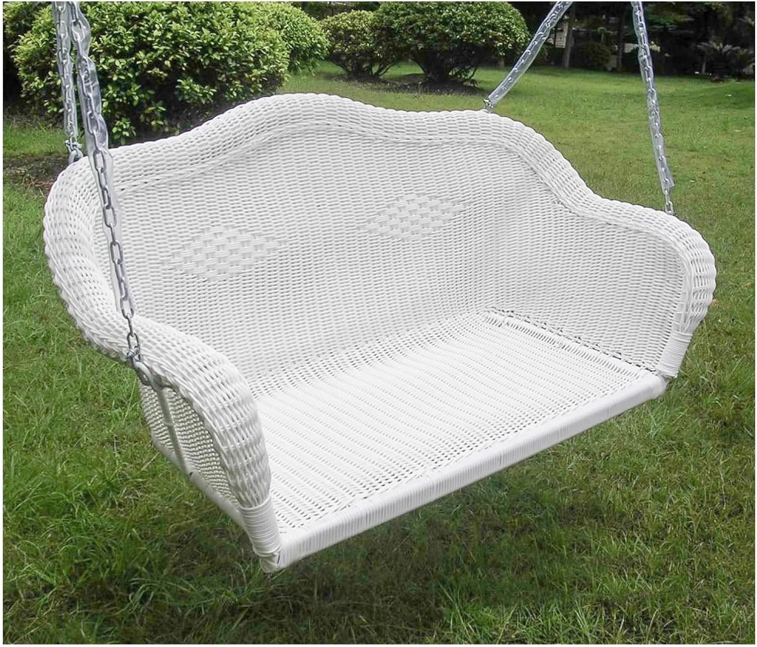 Close-up of the white resin wicker swing on a lawn, showing the attachment points for the chains.